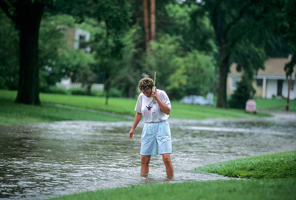 Woman Talking On Vintage Cordless Phone While Standing In Flooded Street