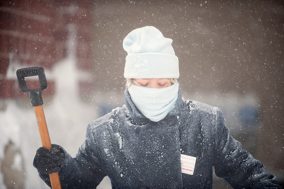 Woman in Winter Storm Holding Snow Shovel