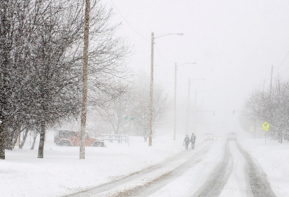 Two People Walking in Whiteout Conditions During Blizzard