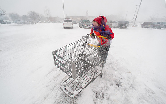 Grocery Store Employee Pushing Cart During Snow Storm