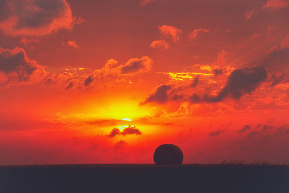 Sun Over Farmland and Hay Bale