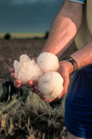 Man Holding Softball-Sized Hailstones