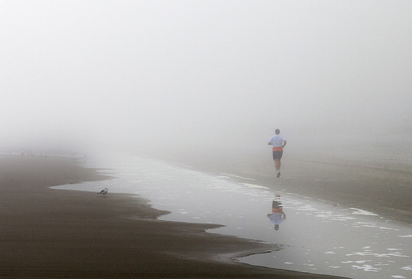 Man Running on Beach in Fog