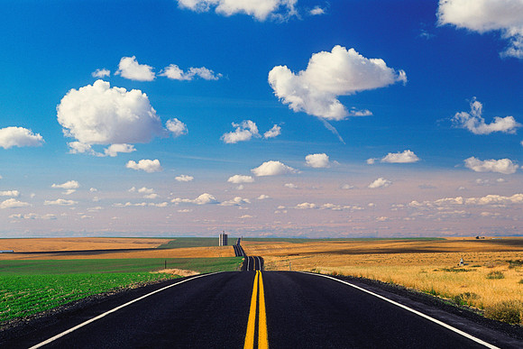 Asphalt Road With Lots of Cumulus Clouds